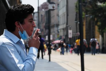 Hombre fumando en la calle de Madero en el Centro Histórico