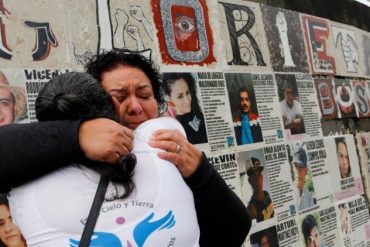 Mujeres se abrazan frente al mural de la glorieta de los desaparecidos en la CDMX